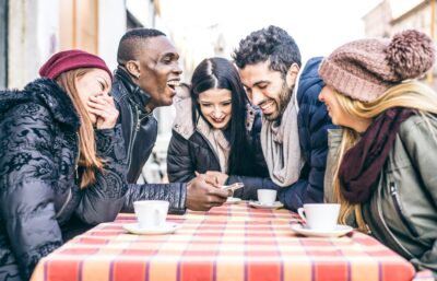 friends laughing at coffee table enjoying winter break